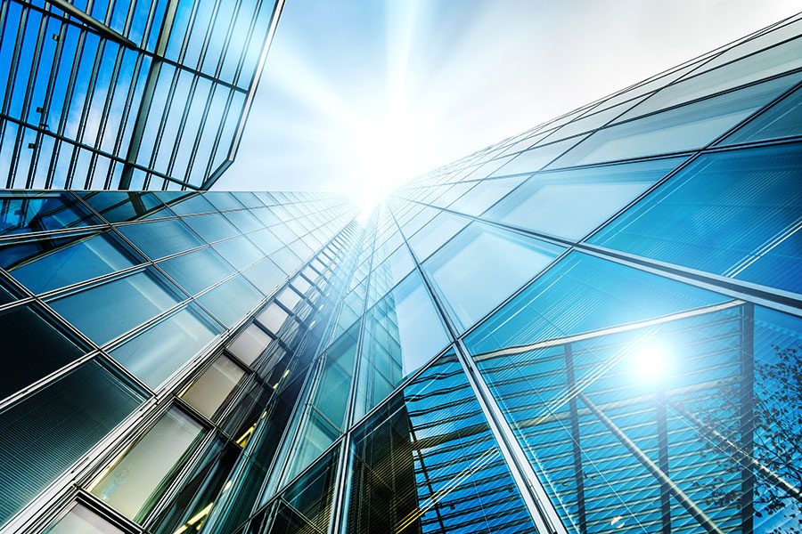 About Our Agency - Looking Up at Modern Business Building with Blue Reflective Windows